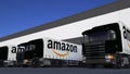 Freight semi trucks with Amazon.com logo loading or unloading at warehouse dock. Editorial 3D rendering