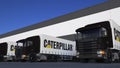 Freight semi trucks with Caterpillar Inc. logo loading or unloading at warehouse dock. Editorial 3D rendering