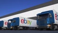 Freight semi trucks with eBay Inc. logo loading or unloading at warehouse dock. Editorial 3D rendering