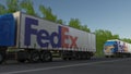 Freight semi trucks with FedEx logo driving along forest road. Editorial 3D rendering Royalty Free Stock Photo