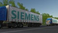 Freight semi trucks with Siemens logo driving along forest road. Editorial 3D rendering