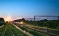 Freight train with lights on while moving in the evening