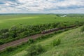 Freight train with locomotives passing by rail in Russia, along the typical Russian landscape, top view