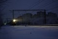 Freight train at night. The headlights and locomotive headlights illuminate the falling snow. Russia Royalty Free Stock Photo