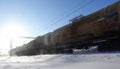 Freight train with oil tanks in motion. Snow dust flies from a passing train at high speed. Frosty sunny day. Winter. Russia Royalty Free Stock Photo