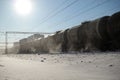 Freight train with oil tanks in motion. Snow dust flies from a passing train at high speed. Frosty sunny day. Winter. Russia Royalty Free Stock Photo