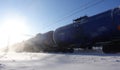 Freight train with oil tanks in motion. Snow dust flies from a passing train at high speed. Frosty sunny day. Winter. Russia Royalty Free Stock Photo