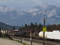 Freight train passing through Jasper, Alberta, Canada. Rocky Mountains in background. Royalty Free Stock Photo