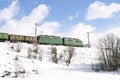 Freight train passing by railways in winter Royalty Free Stock Photo