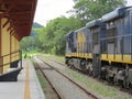 Freight train passing through small station Royalty Free Stock Photo