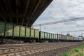 Freight train rides by rail under the road bridge Royalty Free Stock Photo