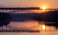 Freight train rides on the railway bridge over the river during sunse Royalty Free Stock Photo