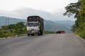 Freight transport truck on a Colombian highway with mountains in the background.