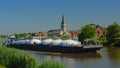 Freighter on river Scheldt with church tower in the flemish countryside