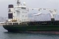 Freighter ship in Hong Kong Harbor and passenger jet at take-off