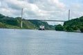 Freighter and tug approaching Centennial bridge near Pedro Miguel locks on the Panama canal