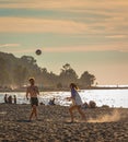 Freinds playing beach volleyball having fun in sporty active life. Young people playing volleyball on beach at sunset