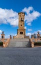 Fremantle, Australia - November 25. 2009: Front side of brown-beige tower at war memorial under blue sky with white clouds
