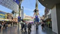 Fremont Street Experience with restaurants and retail stores, people walking, blue sky and clouds in downtown Las Vegas Nevada