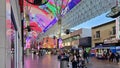 Fremont Street Experience with restaurants and retail stores, people walking, blue sky and clouds in downtown Las Vegas Nevada