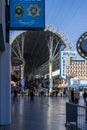 Fremont Street Experience with restaurants and retail stores, people walking and video screens on the ceiling downtown