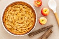 French apple tart aside Gala apples, cinnamon sticks and cooking spoon on a natural linen table cloth. Flat lay. Top view Royalty Free Stock Photo