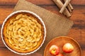 French apple tart aside Gala apples and cinnamon sticks on natural rope mat on a vintage wood table. Flat lay. Top view Royalty Free Stock Photo
