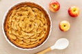 French apple tart aside Gala apples and cooking spoon on a natural linen table cloth. Flat lay. Top view