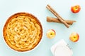 French apple tart aside Gala apples, white bocal, and cinnamon sticks on a light blue background. Flat lay. Top view Royalty Free Stock Photo