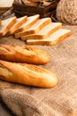 French baguette with slices of bread on tablecloth Royalty Free Stock Photo