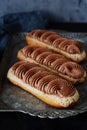 French cake eclair with chocolate cream and crikelin. Delicious dessert. Cake in the glaze. Confectionery product.