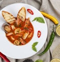 French bouillabaisse fish soup with shrimp, mussels and scallop. In a white plate on a textile background Royalty Free Stock Photo