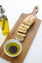 A french bread baguette sliced up on a cutting board with a bowl of olive oil with a splash of balsamic vinegar along side a bott Royalty Free Stock Photo