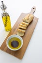 A french bread baguette sliced up on a cutting board with a bowl of olive oil with a splash of balsamic vinegar along side a bott Royalty Free Stock Photo