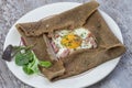 French Buckwheat crepe galette with bacon and egg for tasty healthy lunch on grey wooden background Royalty Free Stock Photo