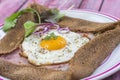 French Buckwheat crepe galette with ham and egg for tasty healthy lunch on a pink wooden background Royalty Free Stock Photo