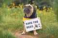 French Bulldog dog wearing bee costume with demonstration sign saying Save the bees Royalty Free Stock Photo