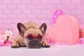 French Bulldog dog wearing pink heart shaped Valentine`s day glasses