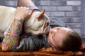 French bulldog on the hands of his master. It is felt that the girl loves her pet and hugs and kiss him tightly.