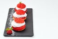 French Cakes with strawberry cream shanti. aery brewing cake on black shale. Restaurant composition on white background. Royalty Free Stock Photo