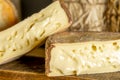 French cheese Saint Nectaire rustic collection delicious. Black background.