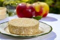 French cheeses collection, piece of fermented cow milk cheese Camembert au Calvados served with apples outside in green garden