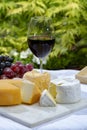 French cheeses collection, yellow Riche de Saveurs, Vieux Pane and Le peche des bons peres cheeses served with glass of red port Royalty Free Stock Photo