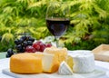 French cheeses collection, yellow Riche de Saveurs, Vieux Pane and Le peche des bons peres cheeses served with glass of red port Royalty Free Stock Photo