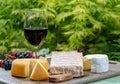 French cheeses collection, yellow Riche de Saveurs, Vieux Pane and Le peche des bons peres cheeses served with glass of red port Royalty Free Stock Photo