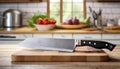 A French chef\'s knife sitting on a chopping board against blurred kitchen background copy space