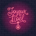 French Christmas red neon light sign on a brick wall dark background. Joyeux Noel calligraphic greeting design. Royalty Free Stock Photo