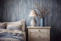 French country bedroom interior. Vintage vase and lamp on the nightstand in rustic style. Neutral blue, grey and white colors Royalty Free Stock Photo