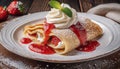 French crepes with cream cheese and whipped cream, topped with strawberry sauce, decorated with mint leaves. Royalty Free Stock Photo