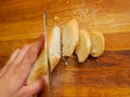 French crisp fresh baguette with a golden crust or a long loaf baked in a bakery and cut into slices on a wooden board